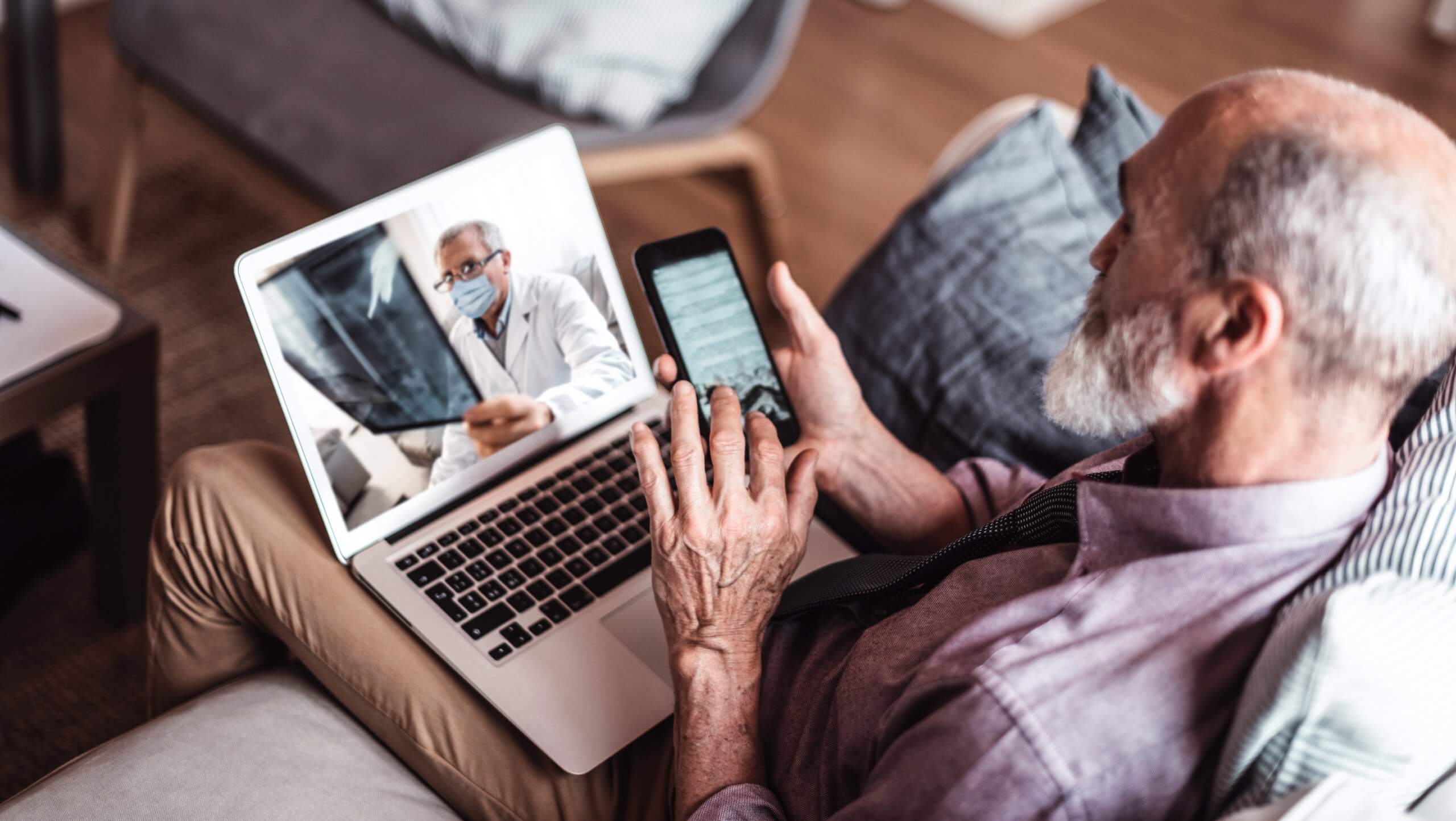 Elderly man looking at a computer screen. He is having a medical diagnosis via video.