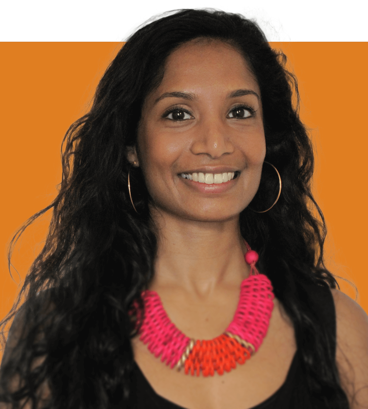Head shot of UK Health lead Nivey Nocher. She is a Sri Lankan woman with long dark hair and brown eyes. She is wearing a large brightly coloured necklace and black vest top as she smiles at the camera.