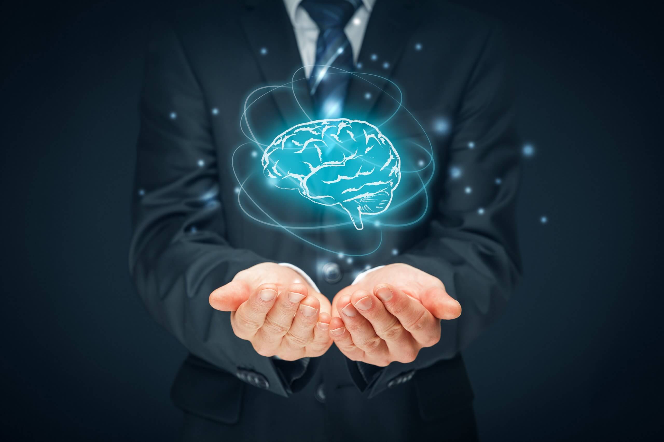 A pair of men's hands held together, facing upwards with a graphic of a brain floating above them.